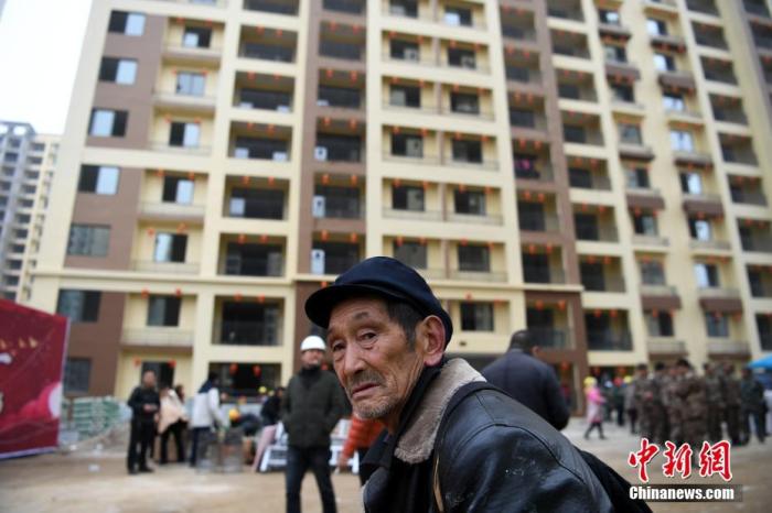 资料图:一名老人在安置房前驻足。<a target='_blank' href='http://www.chinanews.com/'>中新社记者 康平 摄 点击进入下一页