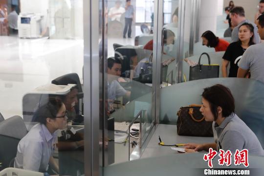 资料图:上海市公安局出入境管理局内,民众正在咨询和办理相关业务。 殷立勤 摄 点击进入下一页