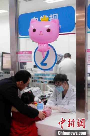 家长带着孩子在上海儿童医院急诊化验科进行检查。 殷立勤 摄
