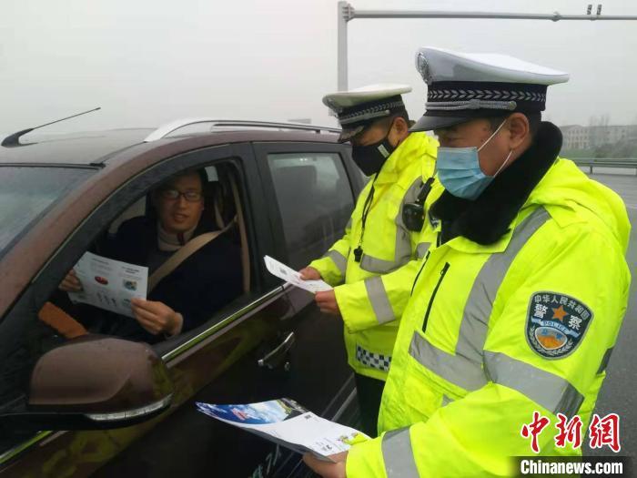 25日，襄阳民警在辖区高速公路出入口对车辆进行核查，宣传防疫知识 杨瑞 摄