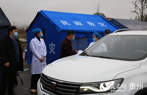 1月27日，工作人员在贵州省毕节北收费站对过往司机和乘客进行检查登记。王纯亮 摄