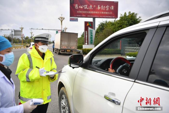 1月30日，云南交警和医务人员对入城车辆及人员进行登记、检测。中新社记者 刘冉阳 摄
