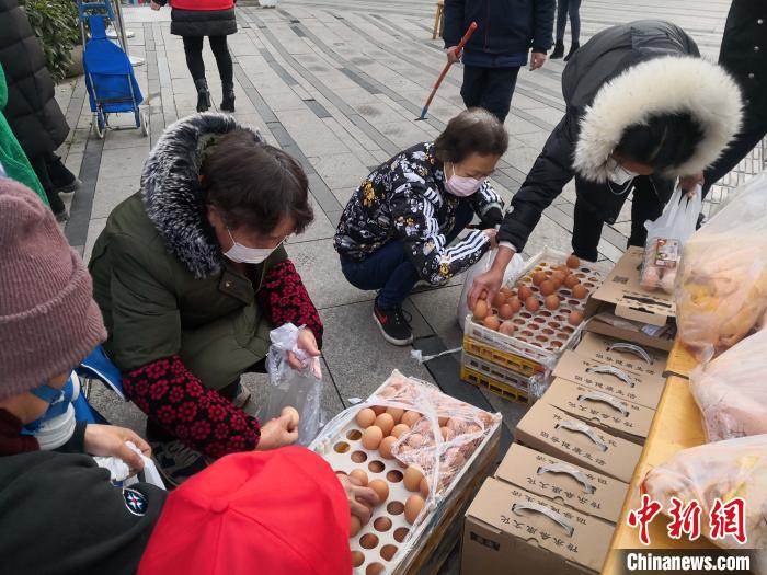居民们正在选购“流动便民菜市”供应的鸡蛋。 陈选斌 摄