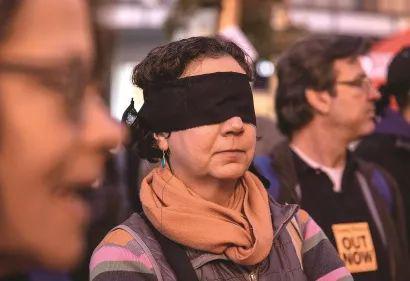  旧金山一名女子用黑布蒙眼，抗议参议院否决针对特朗普的弹劾条款