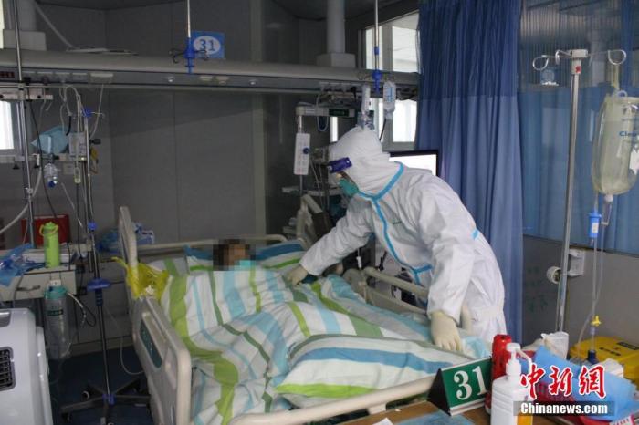 1月25日下午，武汉大学中南医院重症医学科一病区，医护人员正在为新型冠状病毒感染的肺炎危重患者整理被褥。 中新社记者 周群峰 摄