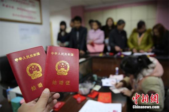 资料图：新人在展示刚领取的结婚证书。 兰自涛 摄