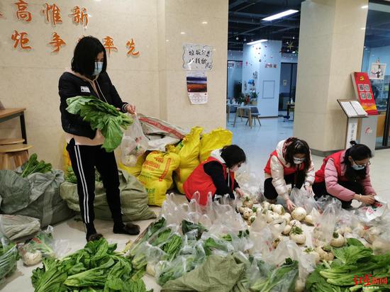 社区工作人员正在分装蔬菜水果