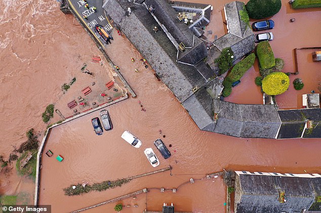 被洪水淹没的房屋和汽车（图片来源：《每日邮报》）