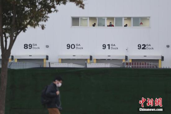 2月10日，特斯拉在上海的超级工厂正式复工复产，成为中国最早一批复工的车企之一。图为生产工间窗口佩戴口罩的员工正常工作。中新社记者 张亨伟 摄