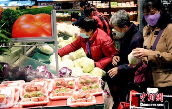 1月27日，农历正月初三，在福州市区一家大型超市，市民戴口罩选购蔬菜。中新社记者 刘可耕 摄