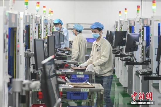 2月20日，位于广州南沙区的安捷利(番禺)电子实业有限公司内，复工人员戴着口罩在生产车间有序工作。中新社记者 陈骥旻 摄