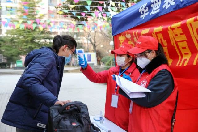 2月21日，党员干部志愿者在安徽合肥市经开区芙蓉社区翡翠湖居委会疫情管控点为返城务工人员测量体温。新华社记者 曹力 摄