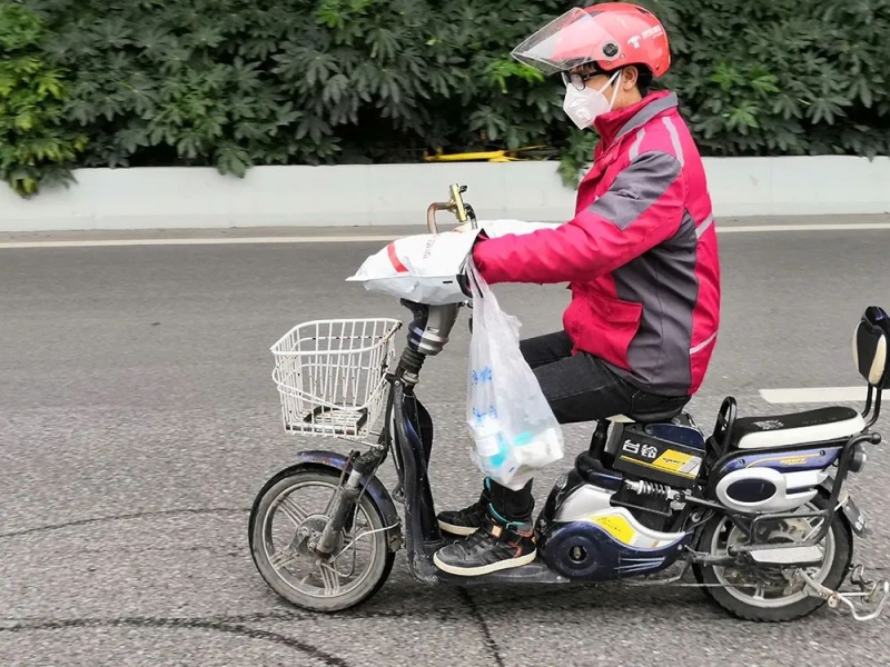 贾胜治骑着电动车为居民买药。