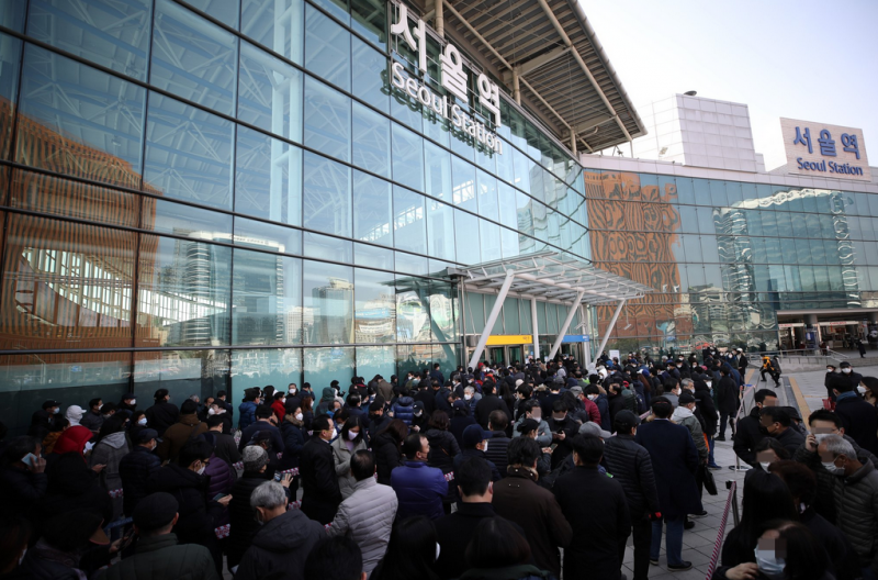 2日下午，首尔站一处口罩销售点附近，市民排起长队。