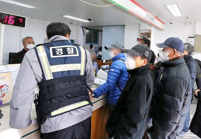 2日上午，京畿道南杨州市一家邮局里，没有拿到号码牌的市民不断抗议，引来警察维持秩序。