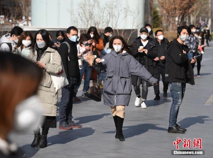 3月2日，北京一些企业的员工在写字楼入口处排队，按要求提供身份信息及接受体温检测后入内办公。中新社记者 侯宇 摄