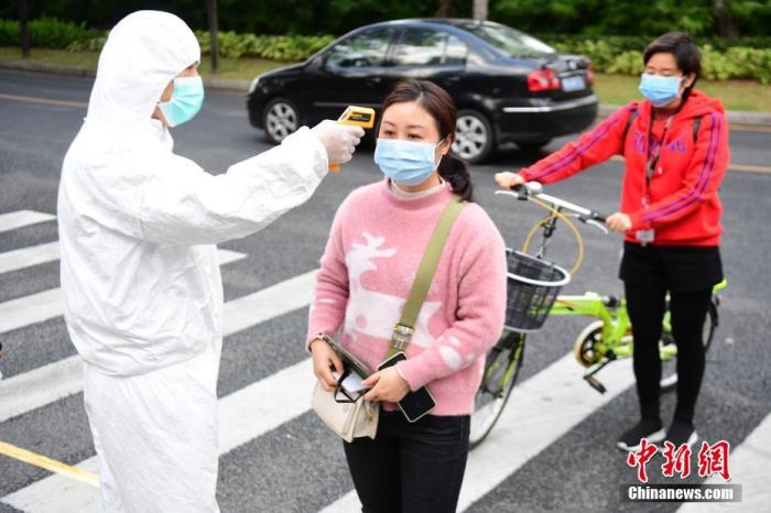 资料图：某公司进入厂区的所有返岗员工以及外来人员须佩戴口罩、测量体温。中新社记者 陈文 摄