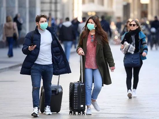 2月24日，在意大利米兰，人们戴着口罩出行。（图片来源：新华社）