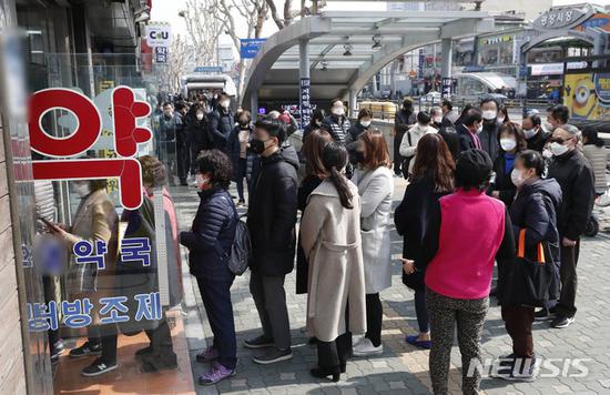 6日，首尔市民排队在药店买口罩。（纽西斯通讯社）