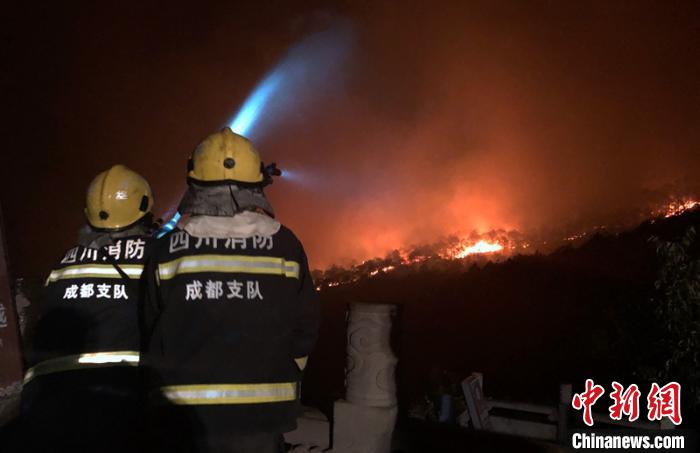 光福寺驻守的消防员对寺院进行喷水降温。 王宇轩 摄