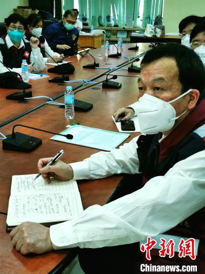中国抗疫医疗专家组成员专注听取情况介绍。 关向东 摄