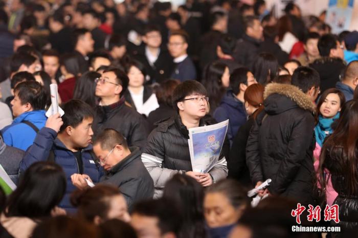 资料图：2017年2月11日，北京国际会展中心举行春季人才招聘会，求职者在招聘会寻找合适的就业岗位。中新社记者 韩海丹 摄