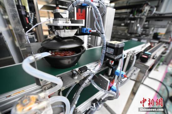 资料图：机器人在制作煲仔饭。中新社记者 石小杰 摄