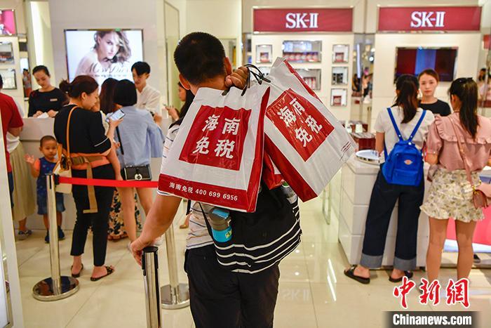 资料图为一位男顾客在海口日月广场免税店内排队买单。 中新社记者 骆云飞 摄
