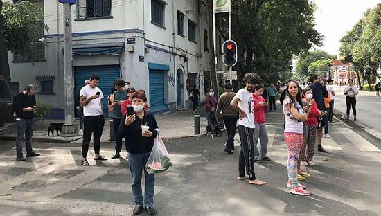  地震发生后，人们站在墨西哥城的街道上。