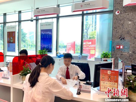 资料图:银行工作人员正在为客户服务。 赵玎 摄 资料图:银行工作人员正在为客户服务。 赵玎 摄
