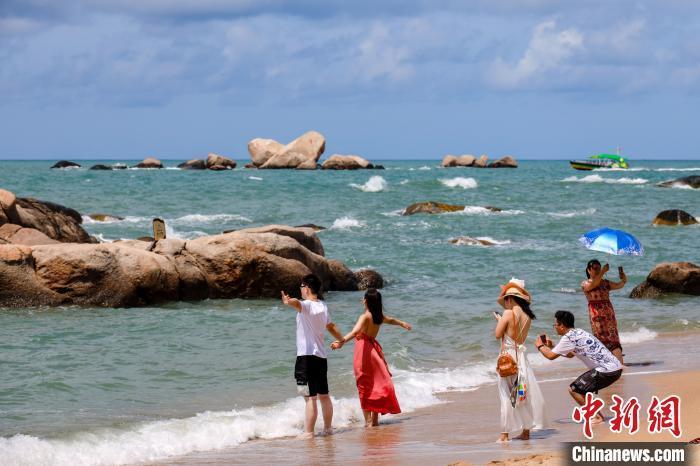 游客在天涯海角的海边沙滩“拥抱大海”。 范勇 摄 点击进入下一页