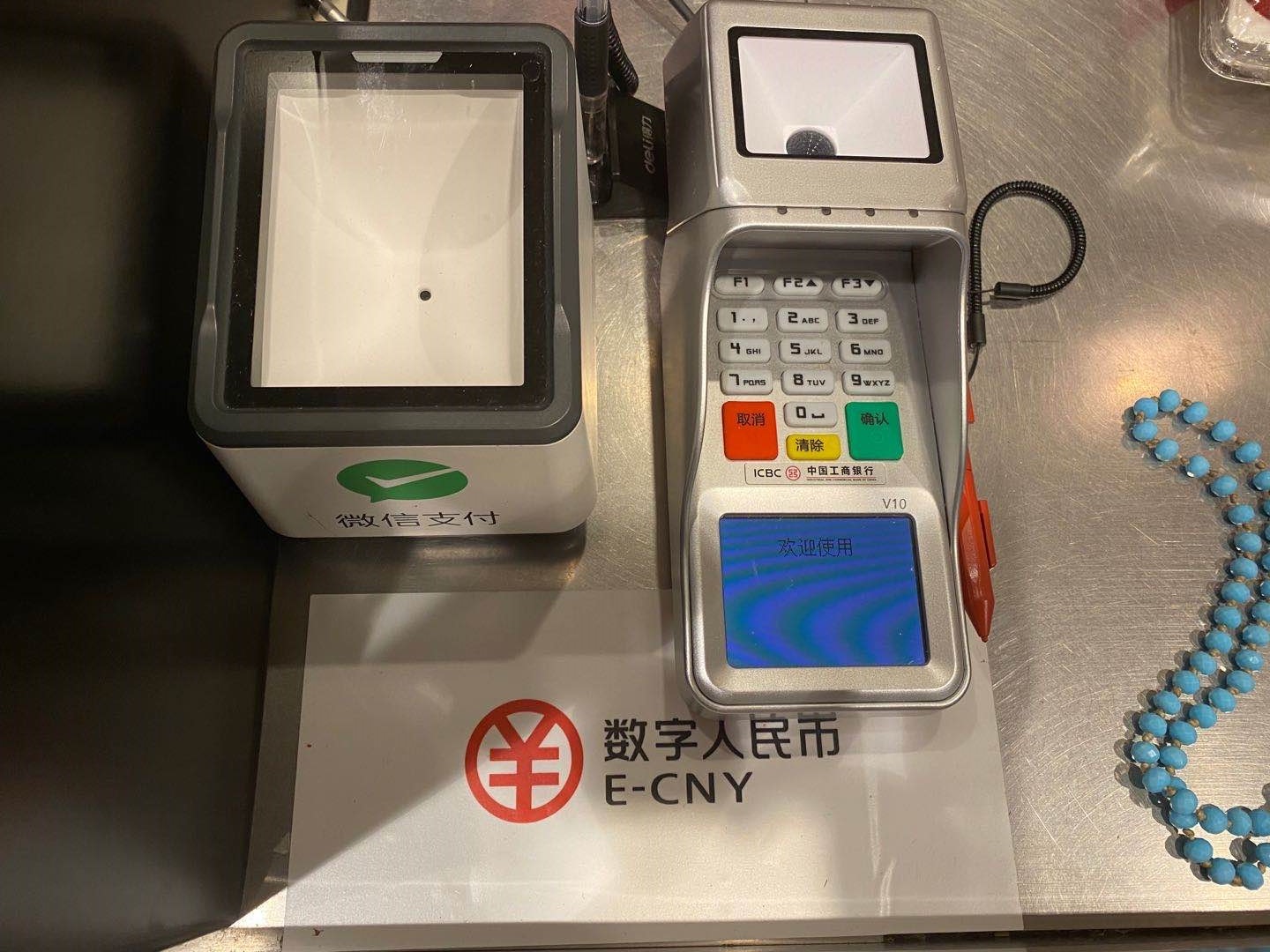 一家商户收银台上的数字人民币可使用提示以及刷码设备 图 澎湃新闻记者 叶映荷