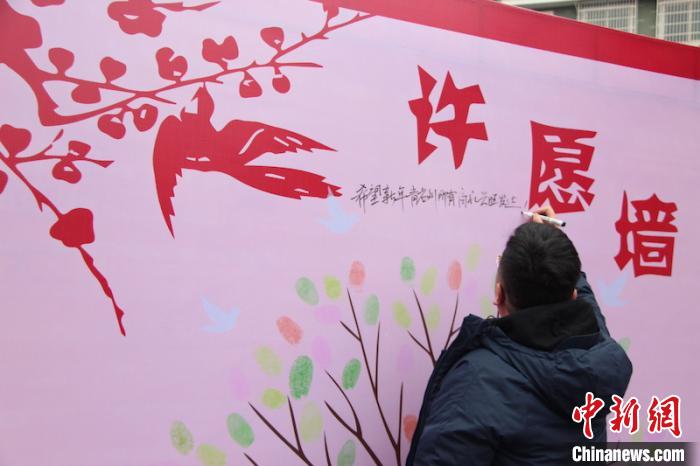 就地过年的人在许愿墙上写下新年愿望。 刘俊豪 摄
